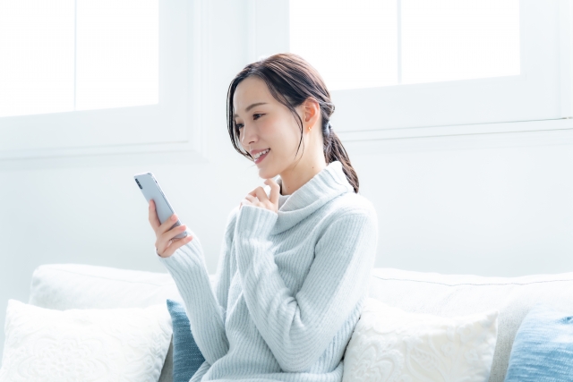 体験の予約をスマートフォンでしている女性