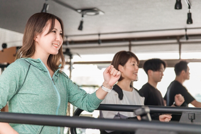 実際にジムで体験している女性とサポートするトレーナー